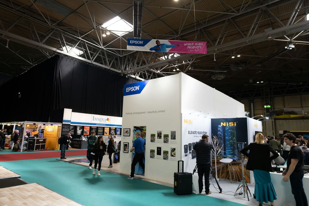 Exhibitors and visitors at organised stands during a business exhibition.